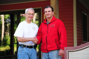 Loren Anderson of St. Germain and formerly Minocqua, turns over the leadership of the Hall of Fame to Craig Marchbank of New Lenox, Ill, newly elected President of the Board of Directors.